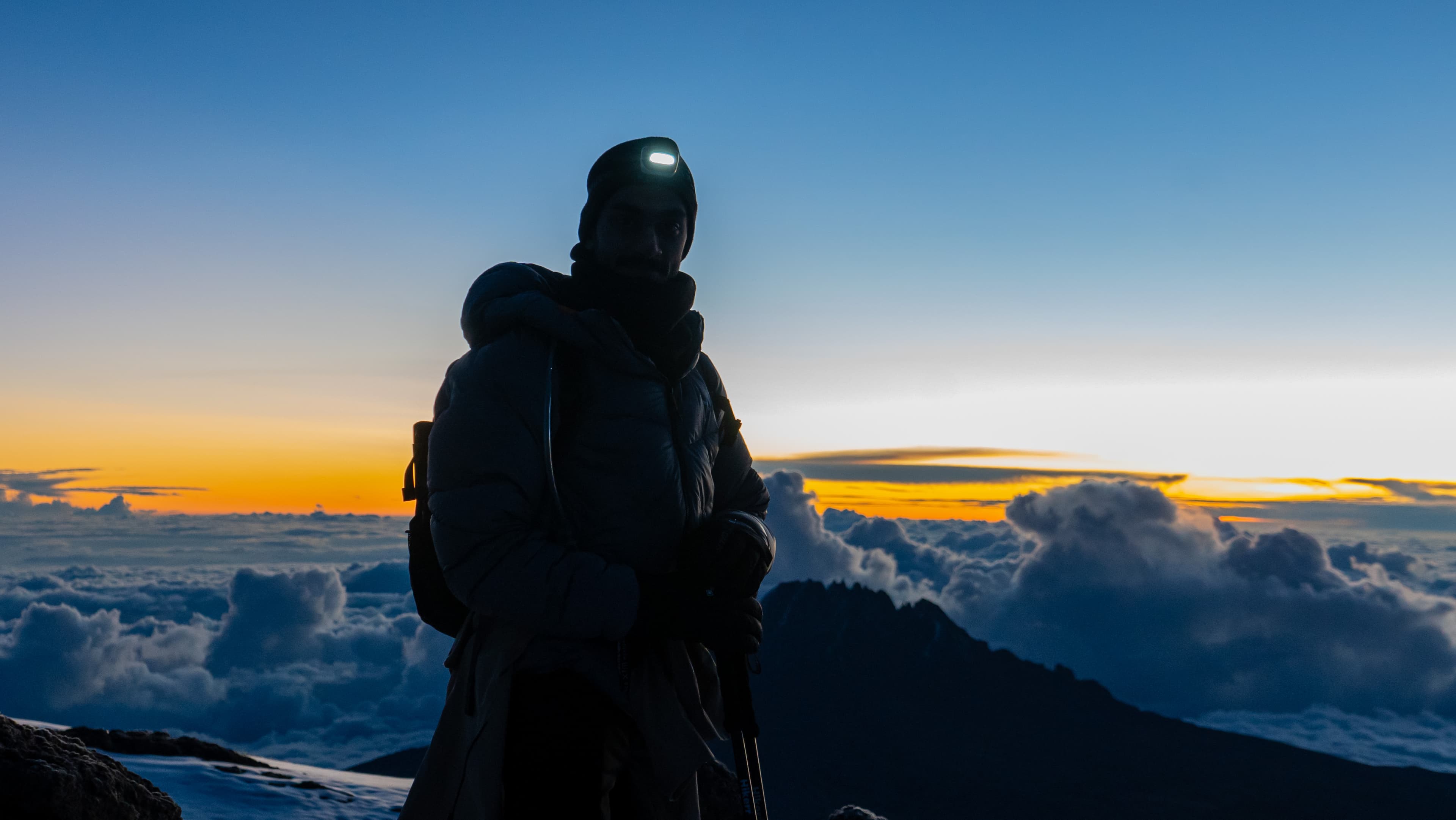 Climber above the clouds at sunset